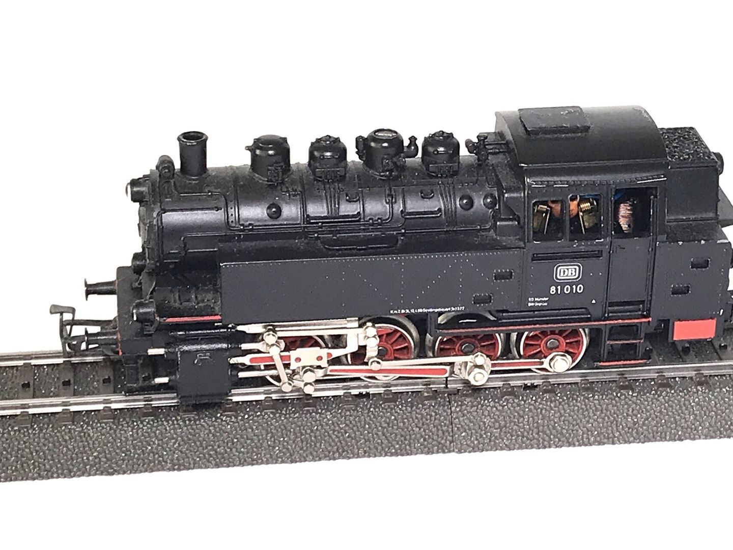 Zwarte H0-stoomlocomotief 81 010 met rode wielen op een grijs kunststof railbed