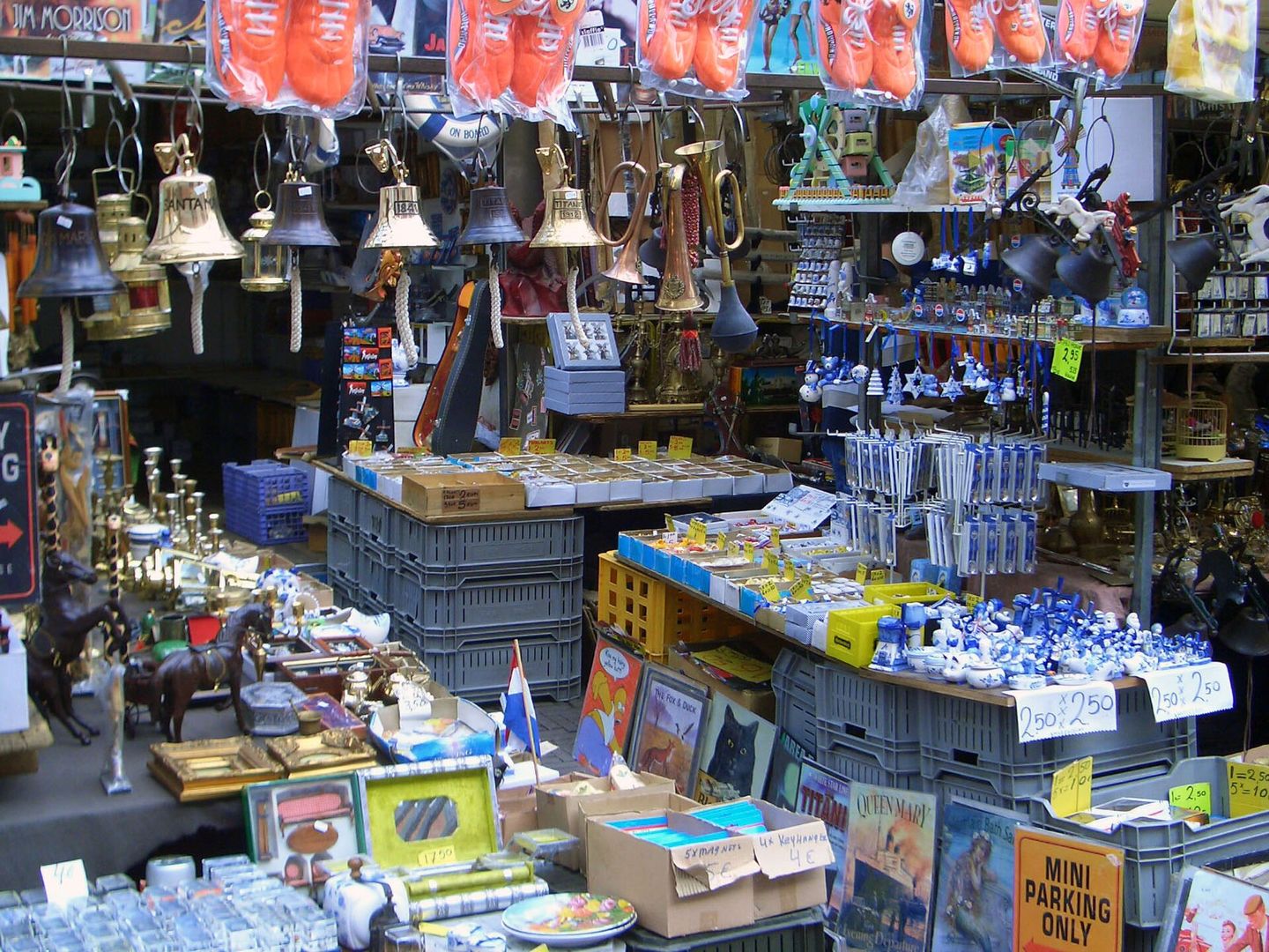 Marktkraam met koperen bellen en lampen aan het dak, Delfts blauw en bordjes in bakken op verschillende hoogtes