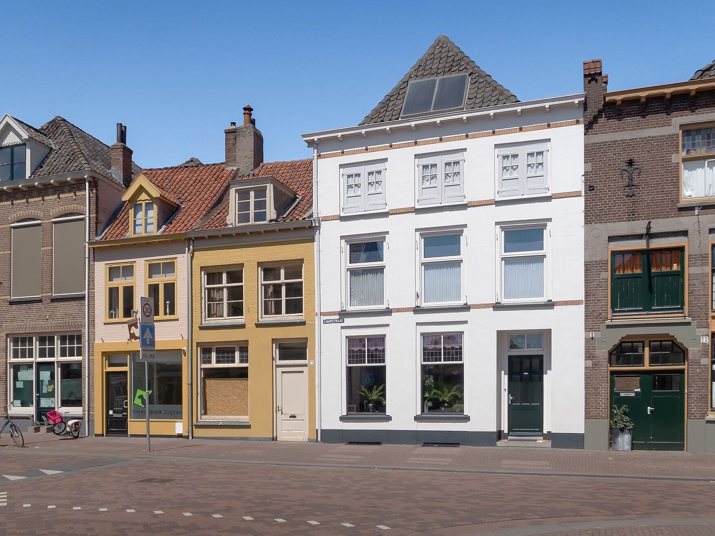 Gevels van historische winkel- en woonpanden in de Laarstraat onder een blauwe lucht