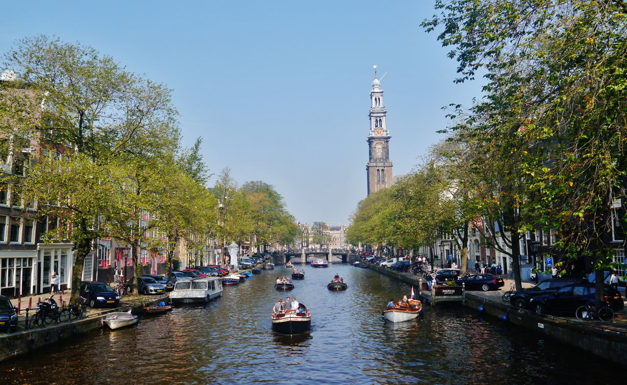 De Prinsengracht met bomen langs de kades en de toren van de Westerkerk