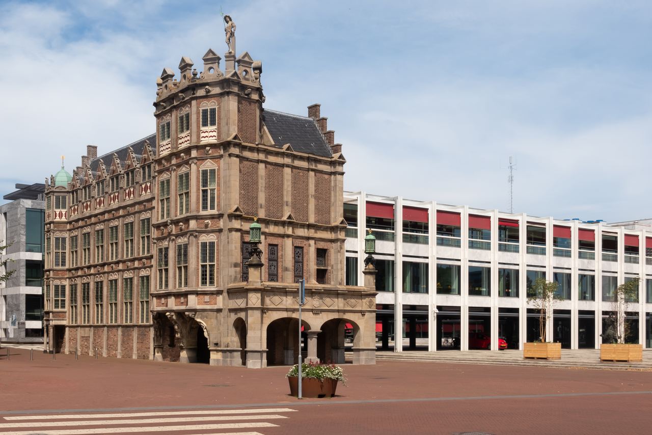 Het Duivelshuis met zijn torentjes en trapgevel naast een deel van het moderne stadhuis