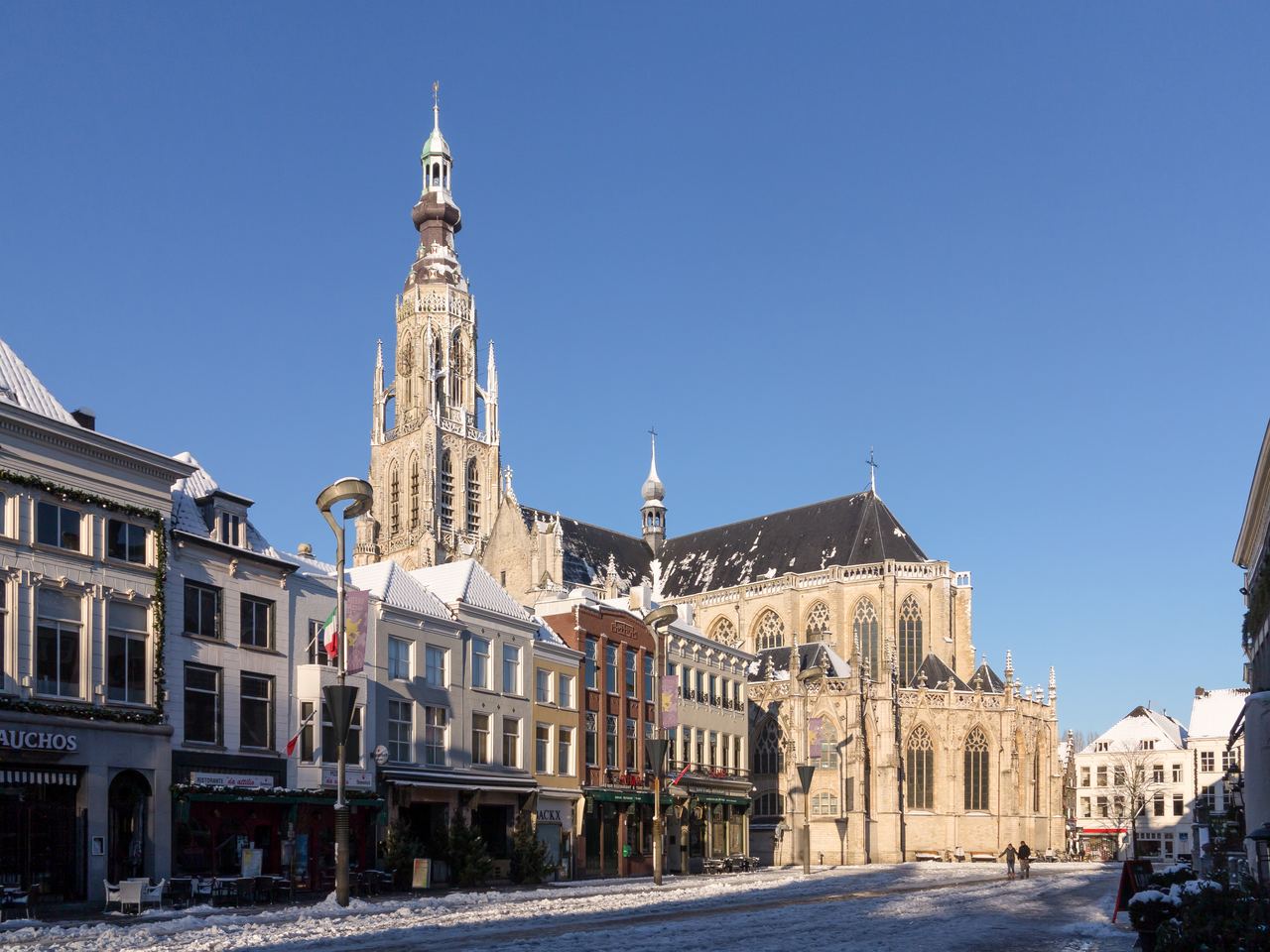De toren van de Grote Kerk boven de gevels aan de Grote Markt