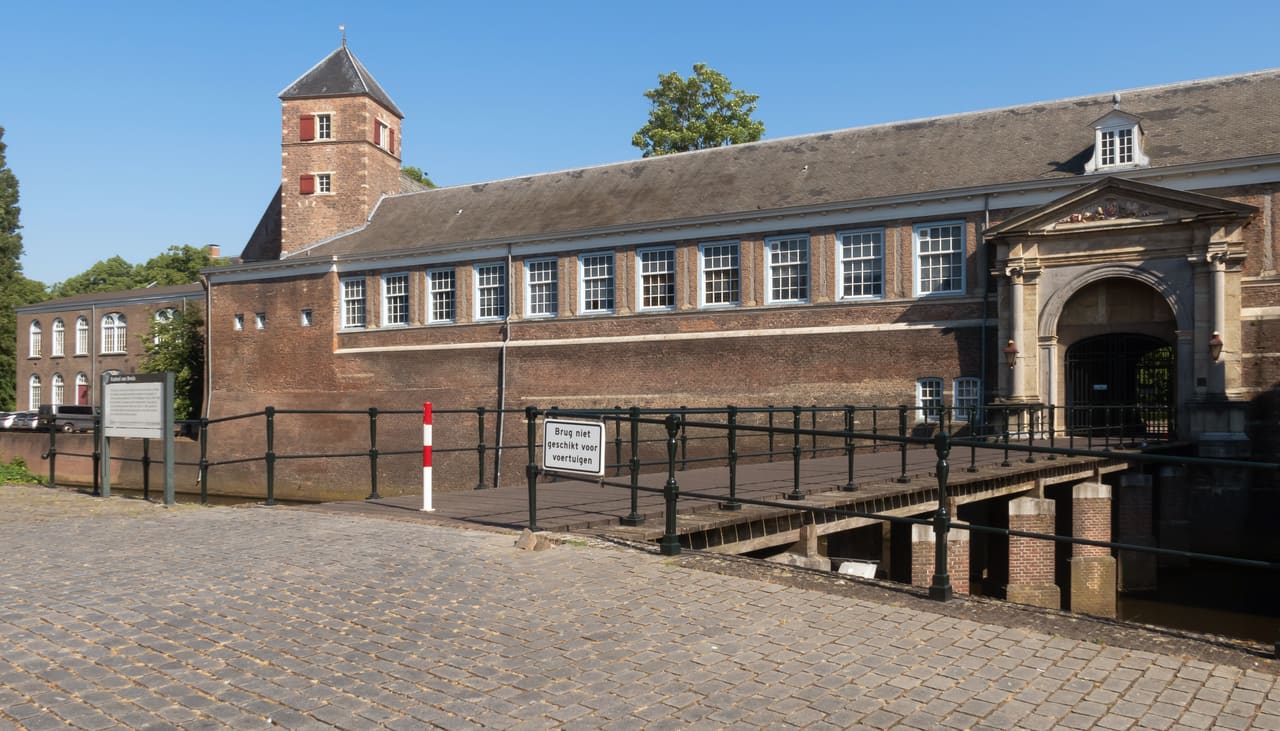 Bakstenen vleugel van het Kasteel van Breda met toren en poort aan een binnenplein