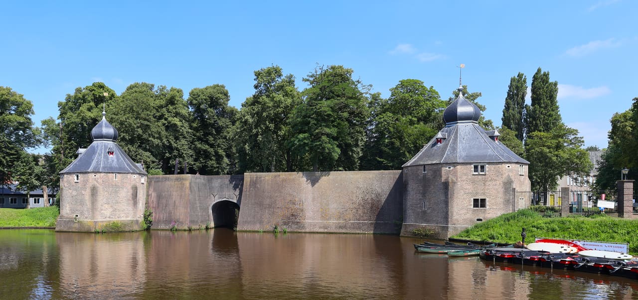 De waterpoort Spanjaardsgat met twee torens, weerspiegeld in het water