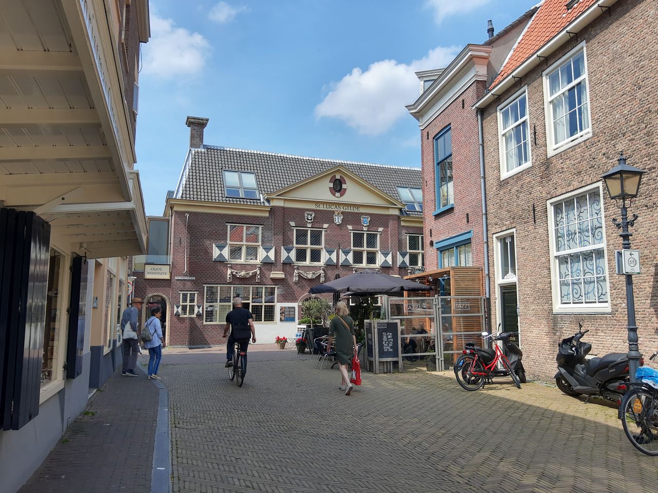 Bakstenen gevel van het Vermeer Centrum aan het eind van een smalle straat