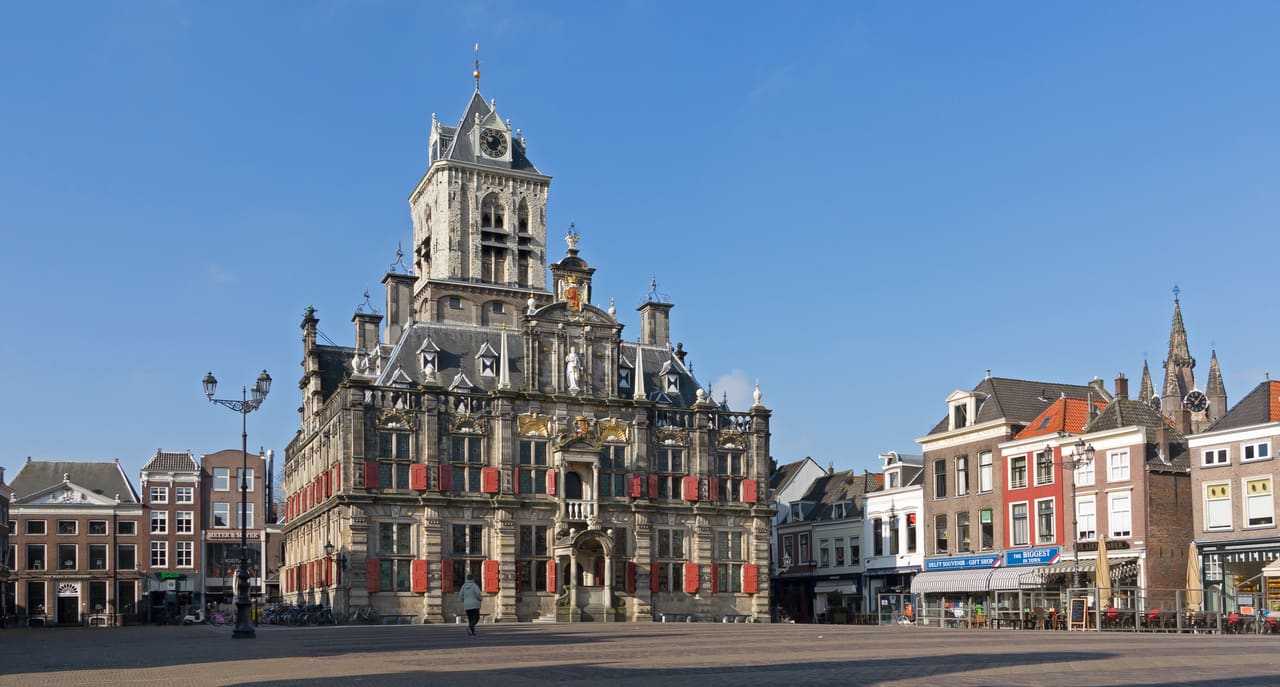 Renaissancegevel van het stadhuis met rode luiken en de toren van Het Steen aan de Markt
