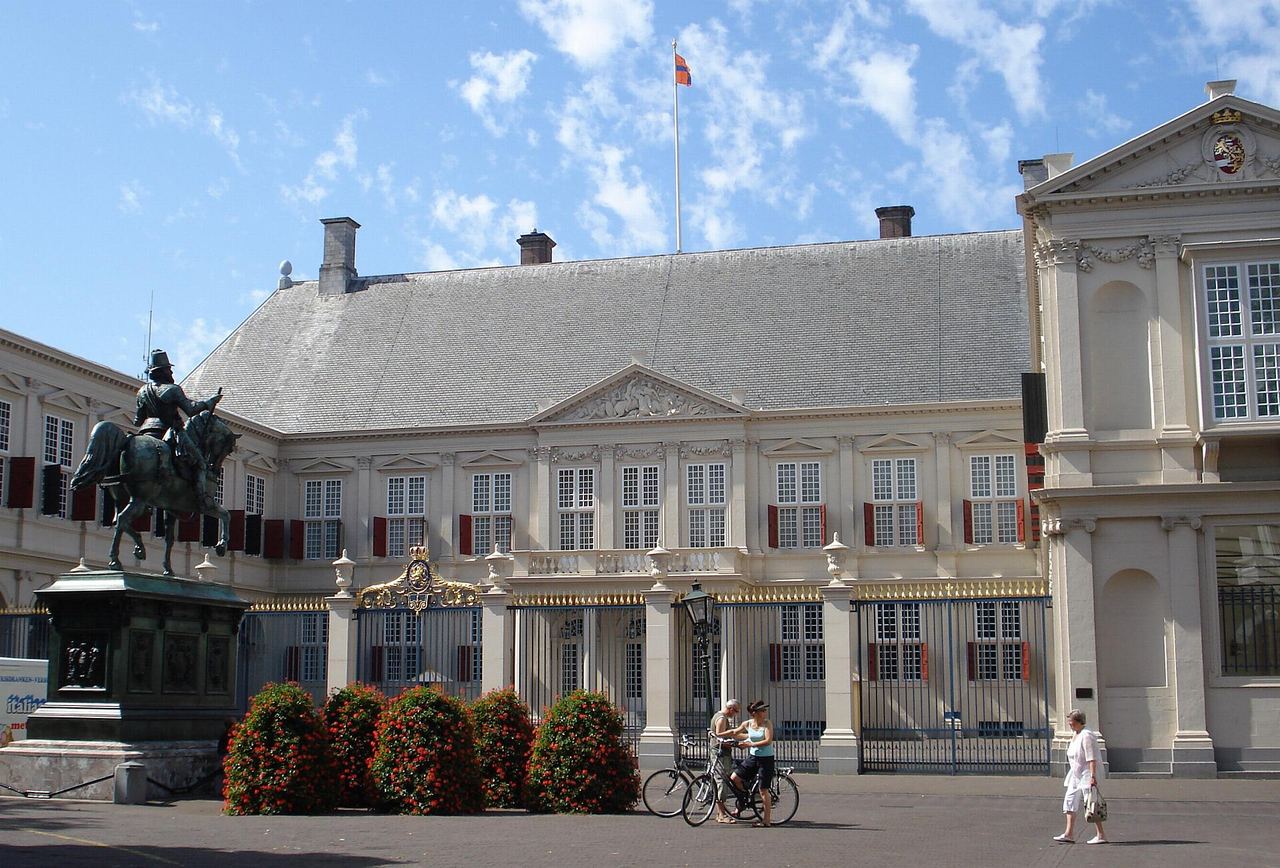 Paleis Noordeinde met het ruiterstandbeeld op het plein ervoor en een hek voor de ingang