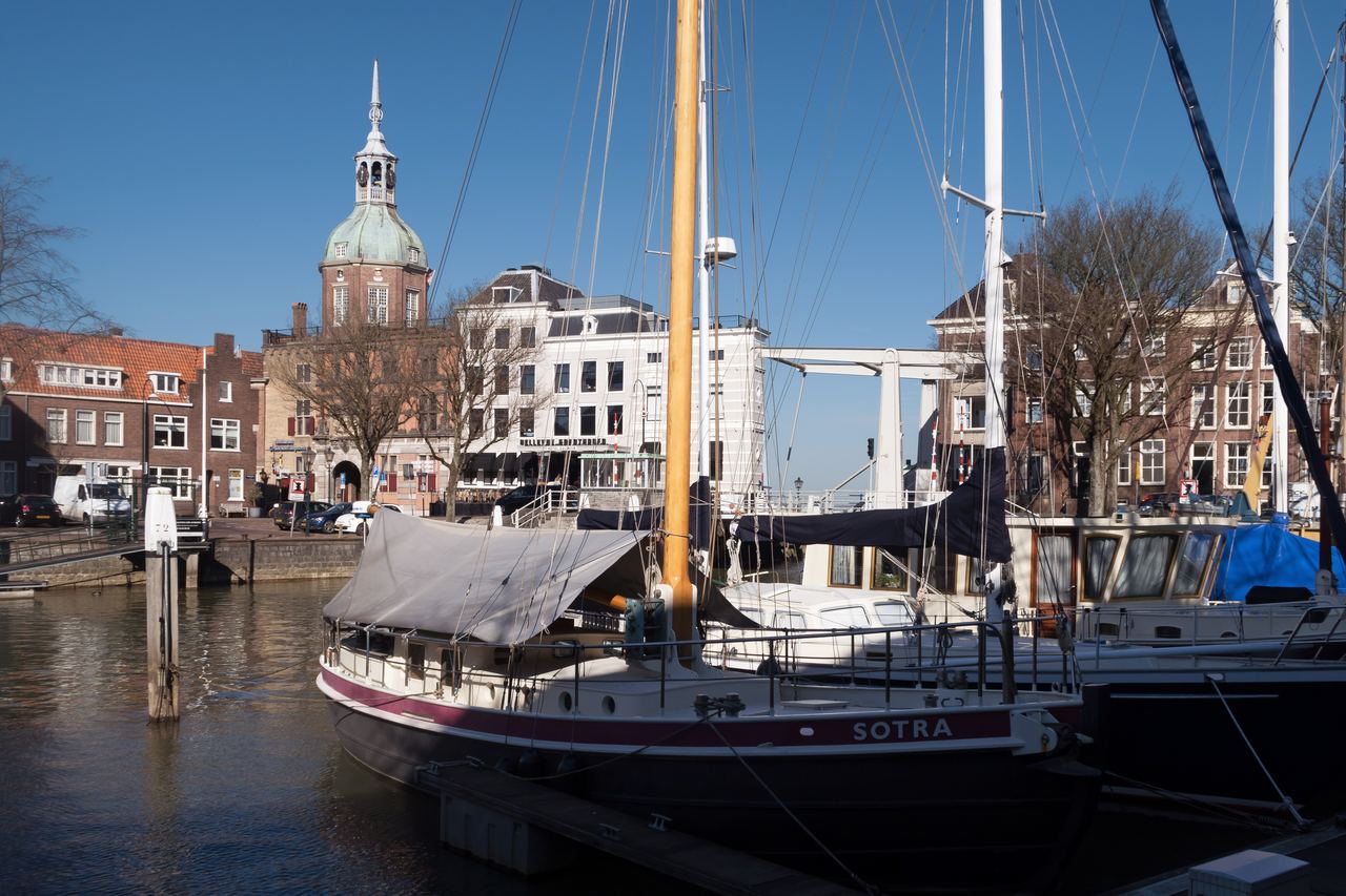 Zeilschepen in de haven bij de Taankade, met op de achtergrond de koepel van de Groothoofdspoort