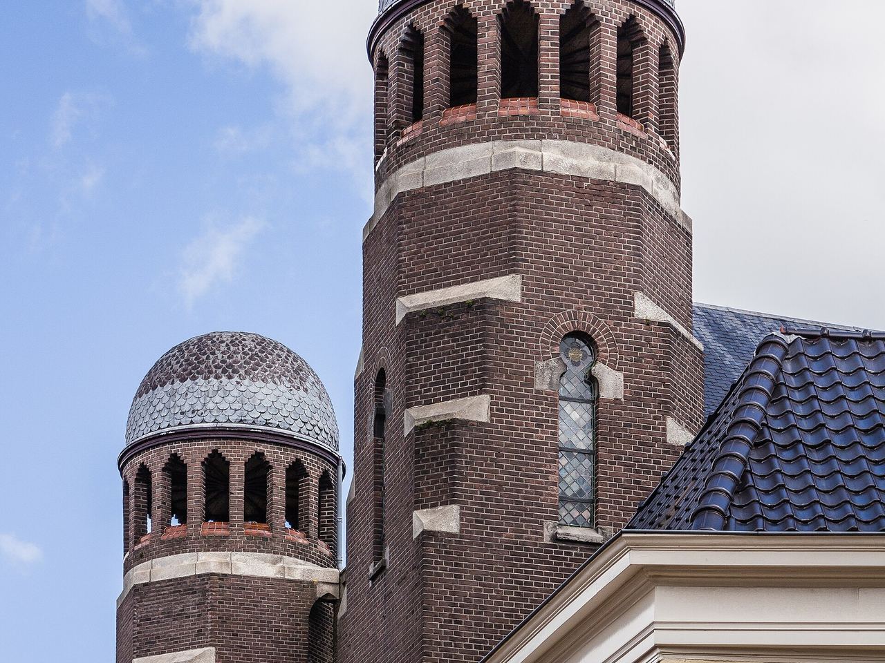De bakstenen torens met koepels van de synagoge aan de Folkingestraat