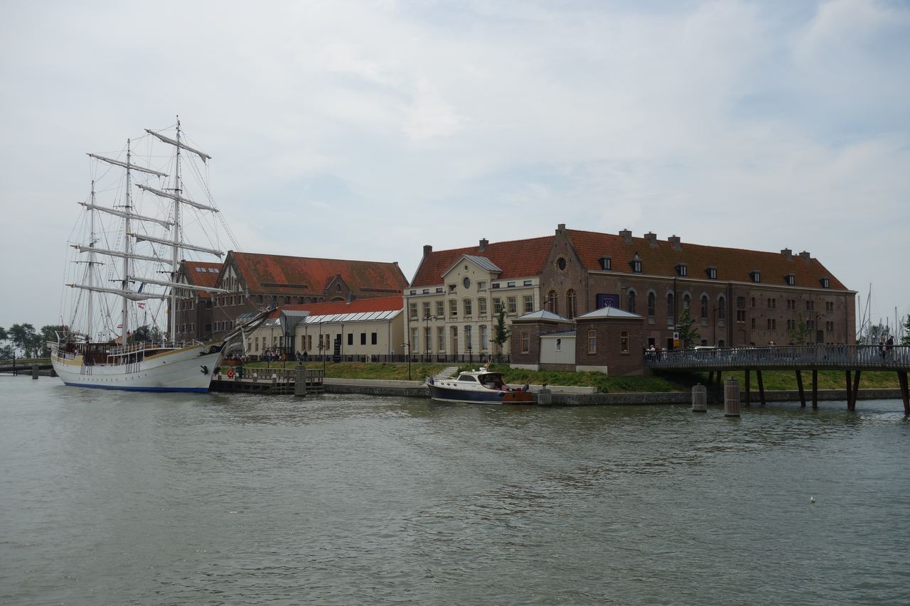 De gebouwen op het Oostereiland met een driemaster aan de kade