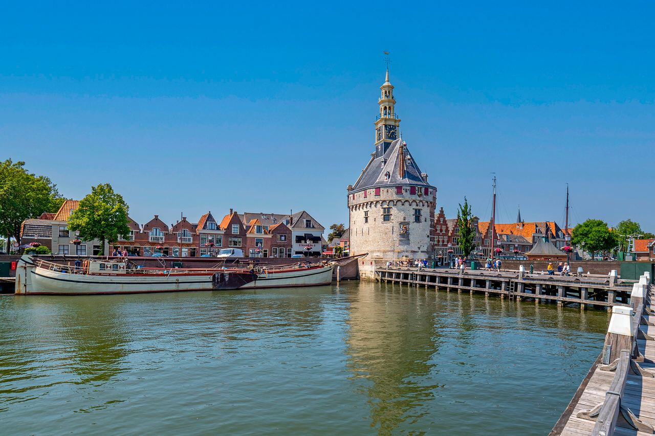 De Hoofdtoren aan de haven van Hoorn, met een platbodem en een houten steiger op de voorgrond