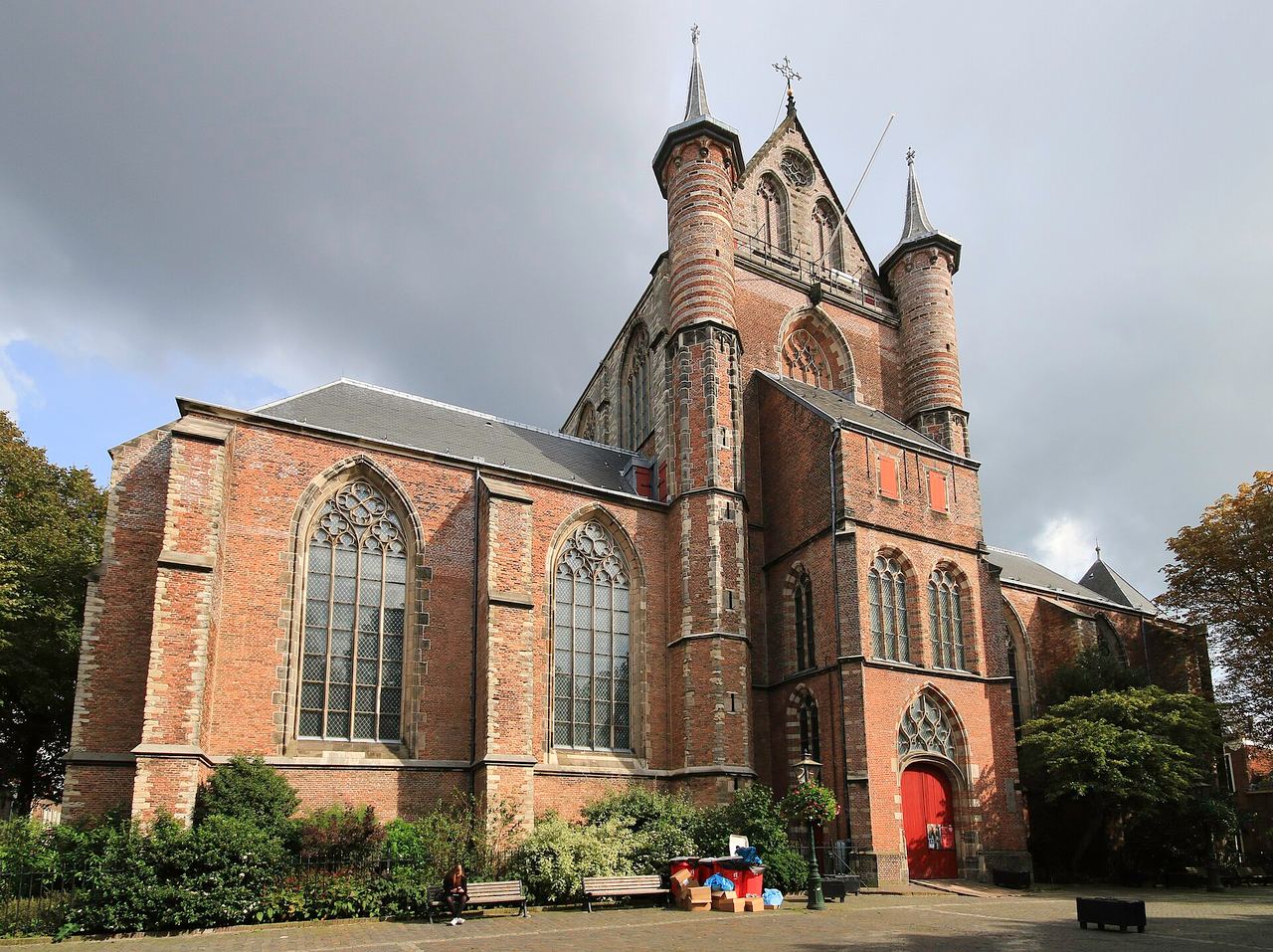 De laatgotische Pieterskerk met hoge spitsboogvensters en traptorens, omringd door groen
