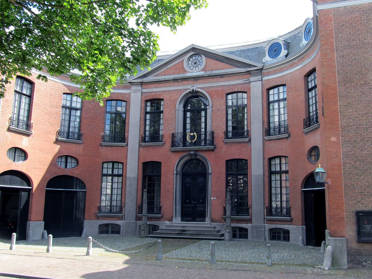Het Van de Perrehuis met gebogen gevel, hoge ramen en smeedijzeren balkonnetjes