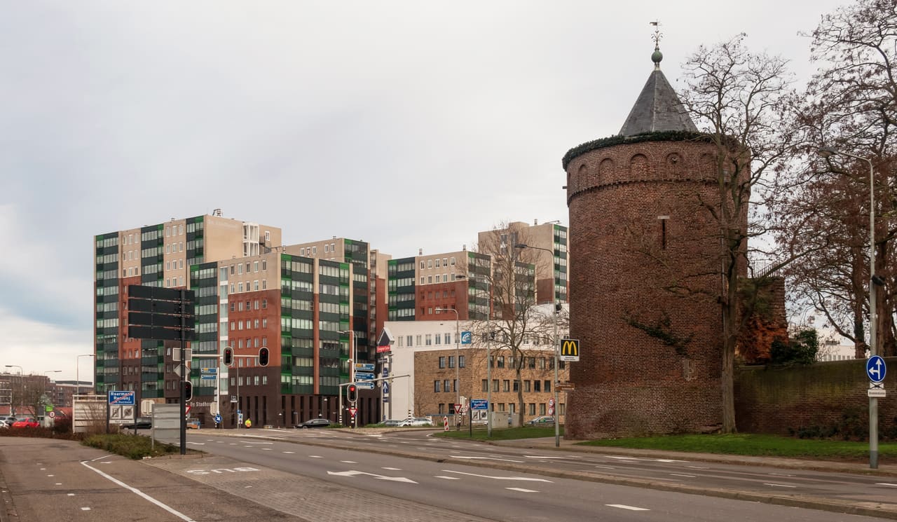 De ronde bakstenen Rattentoren met spitse kap langs een brede straat