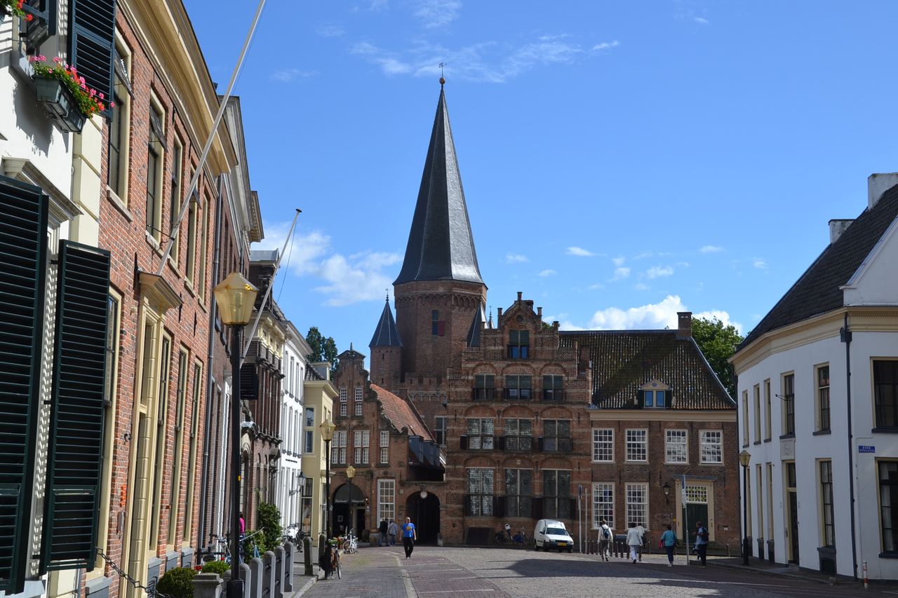 Straat met historische gevels en aan het eind de Drogenapstoren met spits