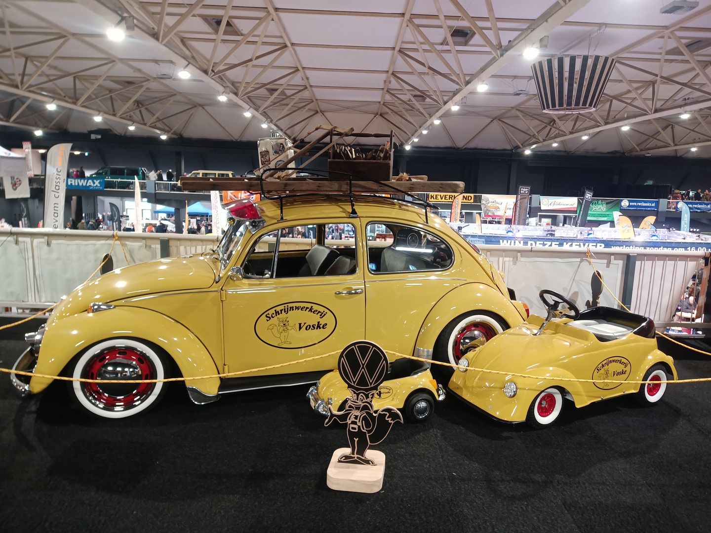 Het hoofdgebouw van Autotron met de naam op het dak, een leeg plein en oldtimers in de herfstzon