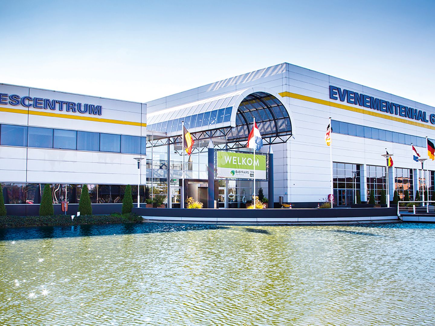 Gevel van de Evenementenhal Gorinchem met de entree en een vijver op de voorgrond