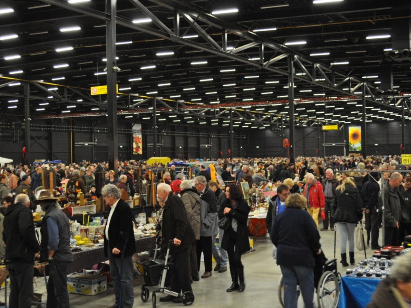 Volle gangpaden tussen de kramen in de grote hal van Expo Assen
