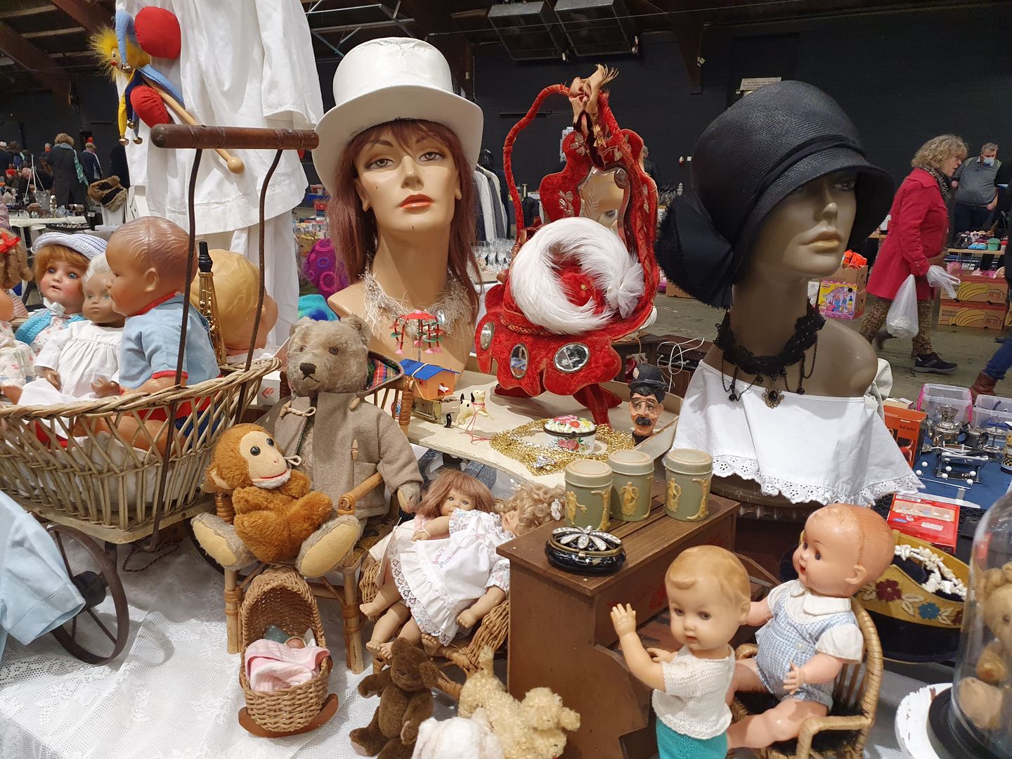 Paspoppen met hoeden, oude poppen en speelgoed op een kraam van de Stadjersmarkt