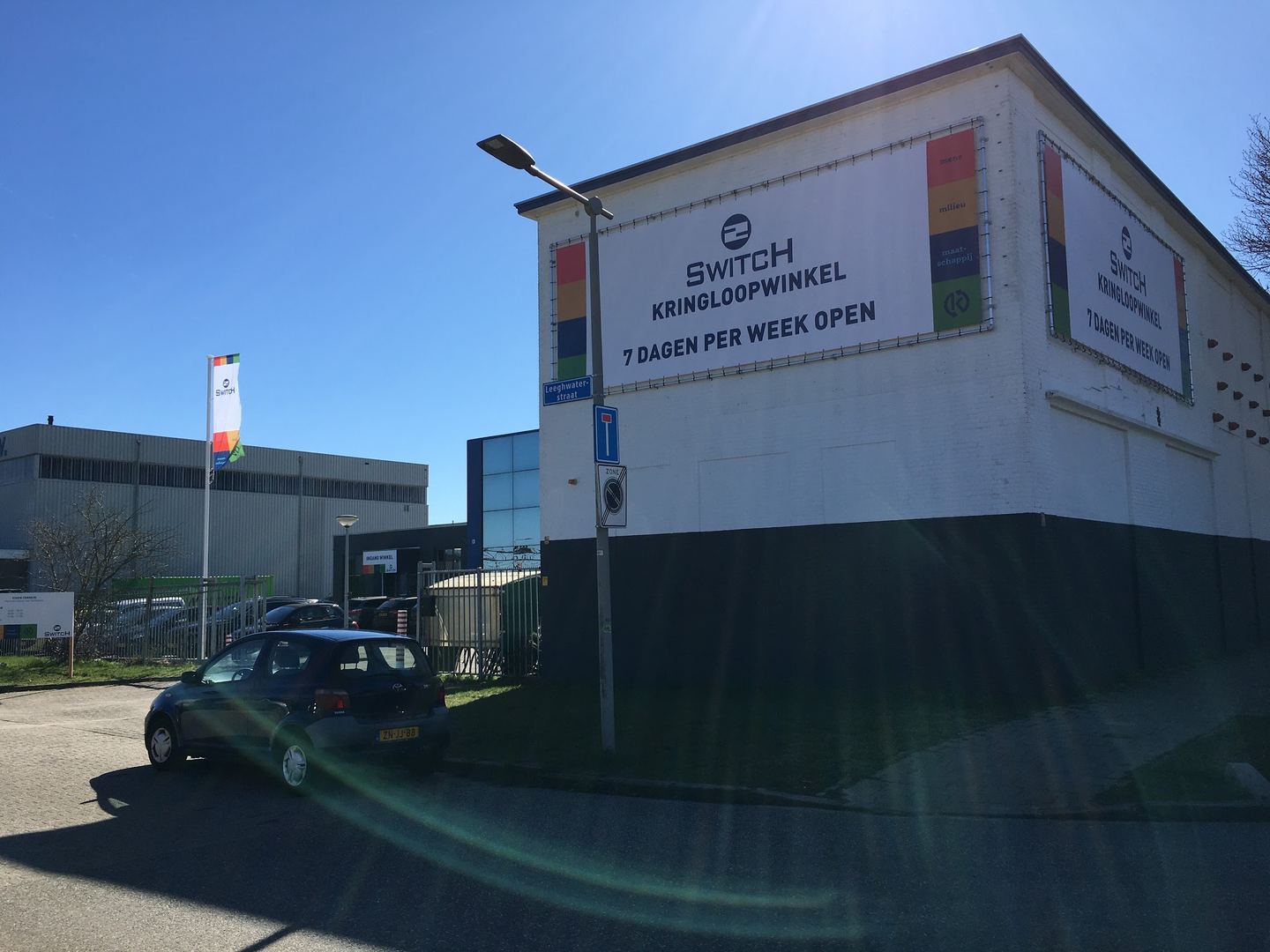 Gevel van 2Switch Arnhem met bord Kringloopwinkel, zeven dagen per week open