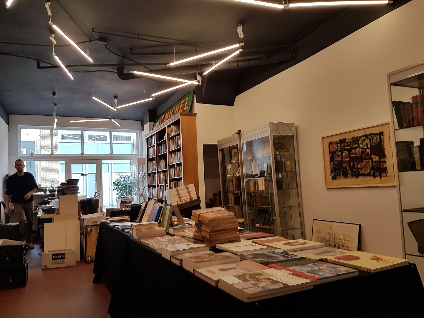 Lange tafel met kunstboeken, vitrines en boekenkasten in Antiquariaat Berger & De Vries