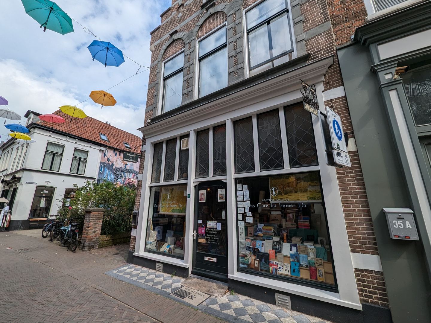 Gevel van Antiquariaat Das Gute Ist Immer Da met etalages vol boeken
