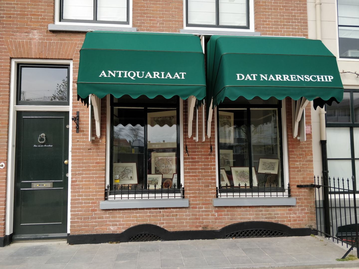 Gevel van Antiquariaat Dat Narrenschip met groene luifels en oude kaarten en prenten in de etalages
