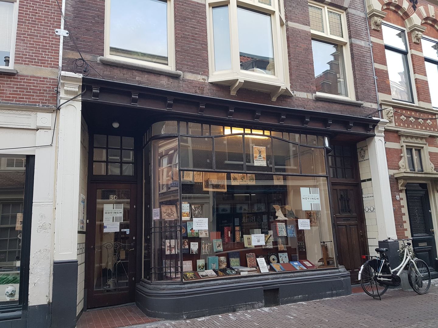 Gevel van Antiquariaat Hovingh met houten winkelpui en etalage vol boeken en prenten