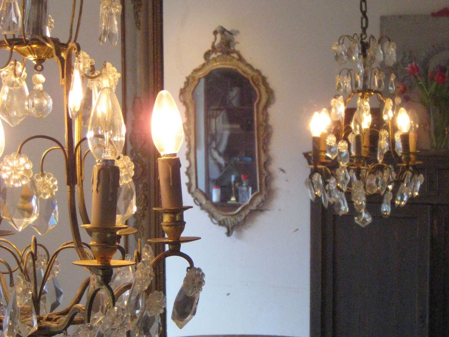 Kristallen kroonluchters en een vergulde spiegel in het interieur van Antique Interiors