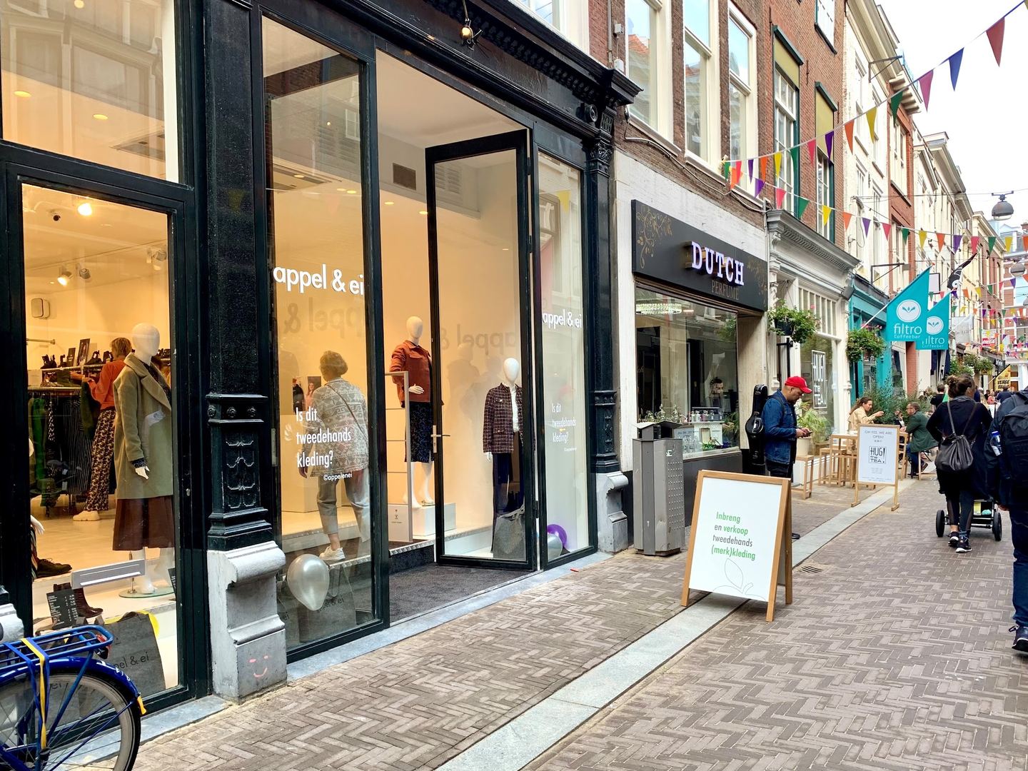 Zwarte winkelpui van Appel & Ei met grote etalageruiten, paspoppen in de etalage en een stoepbord in de winkelstraat