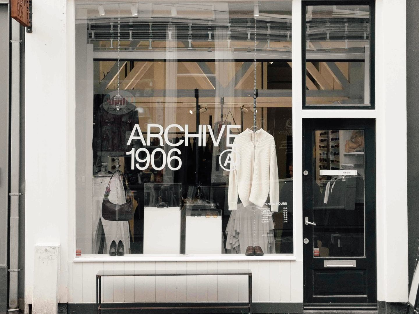 Gevel van Archive 1906 met kleding en een tas in de etalage