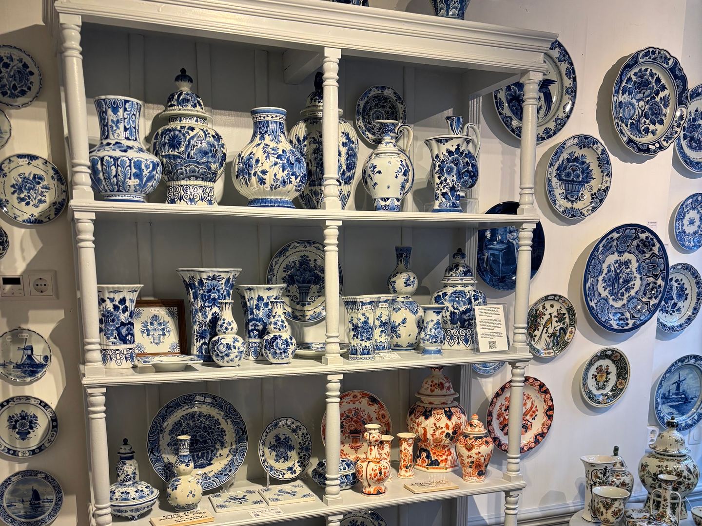 Interieur van Blauwe Roos Antiek met witte kasten vol blauw-wit aardewerk, vazen en borden