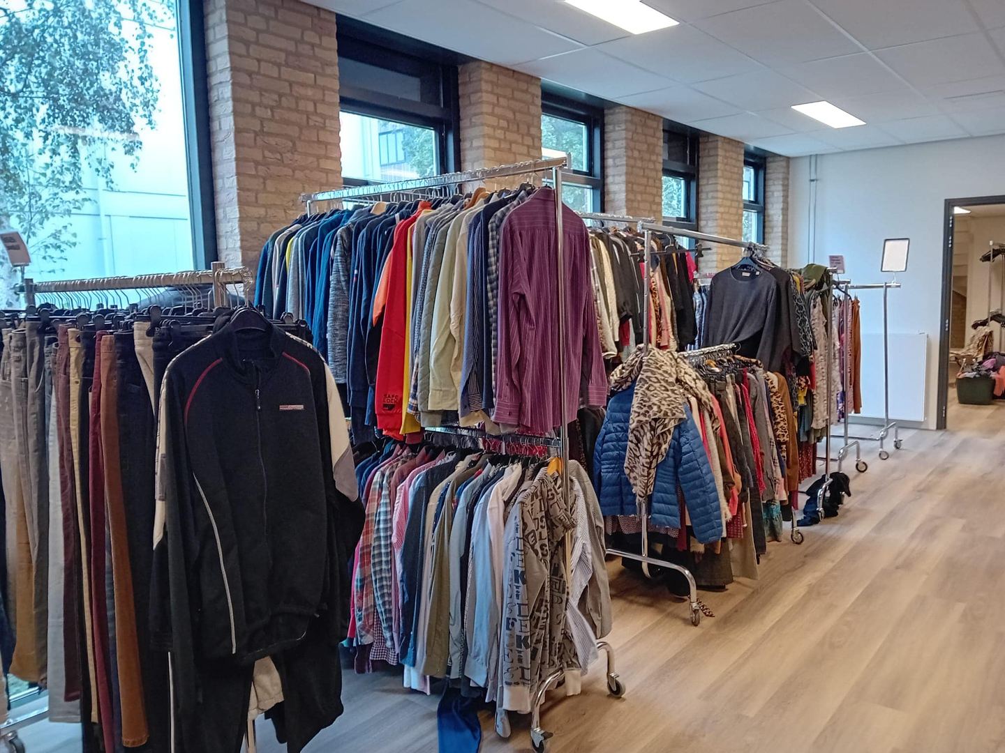Rekken met tweedehands kleding in de Boothiek