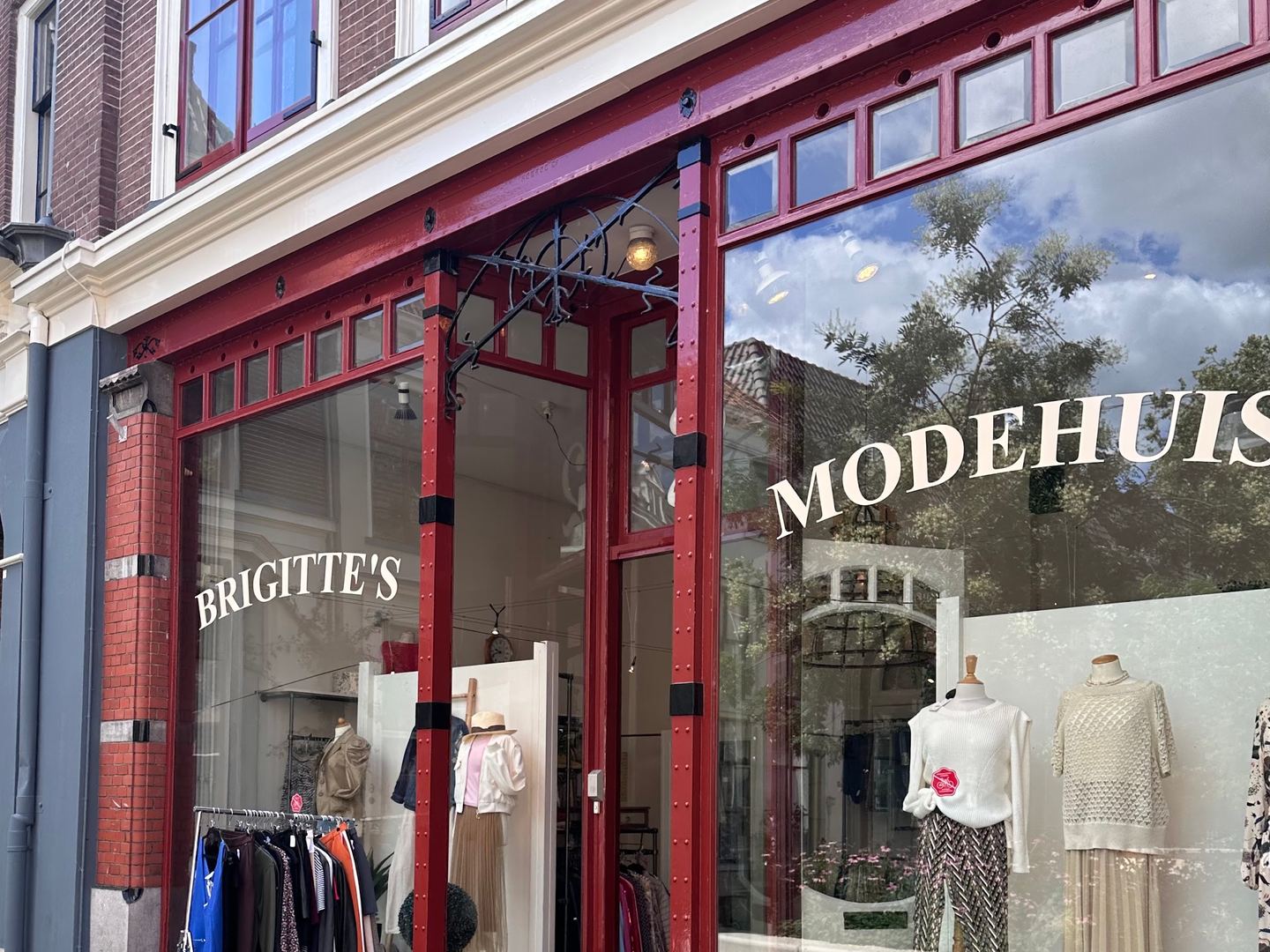 Rode winkelpui van Brigitte's Modehuis met etalages vol tweedehands dameskleding
