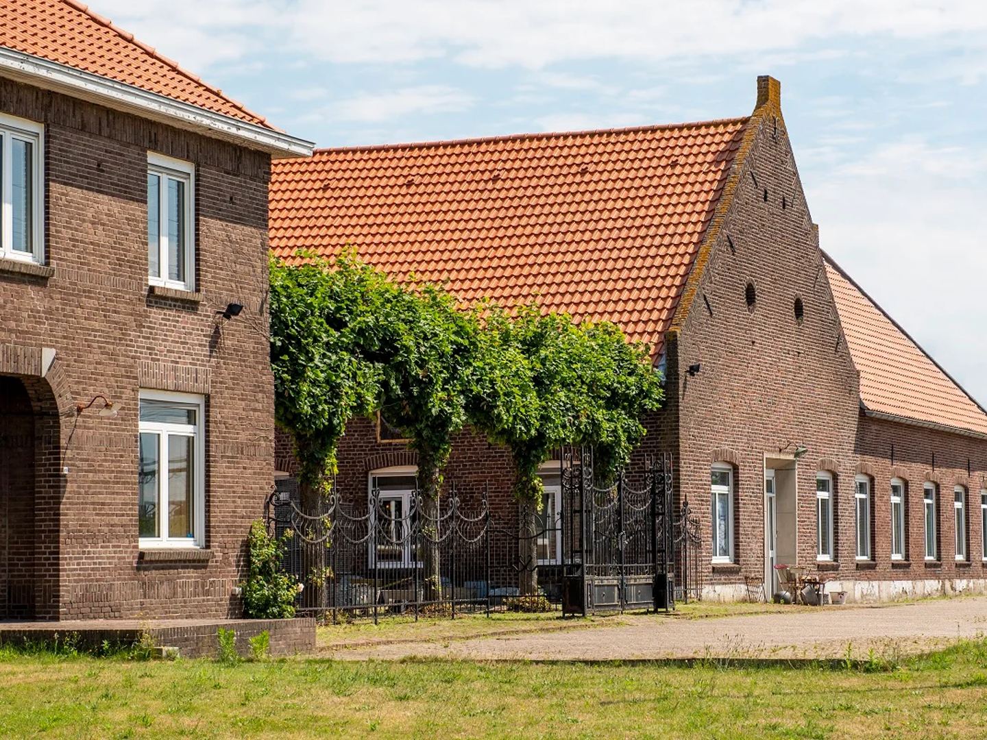 Exterior view of a brick building with a red tiled roof, likely the location of Chateau Noir Antiques.