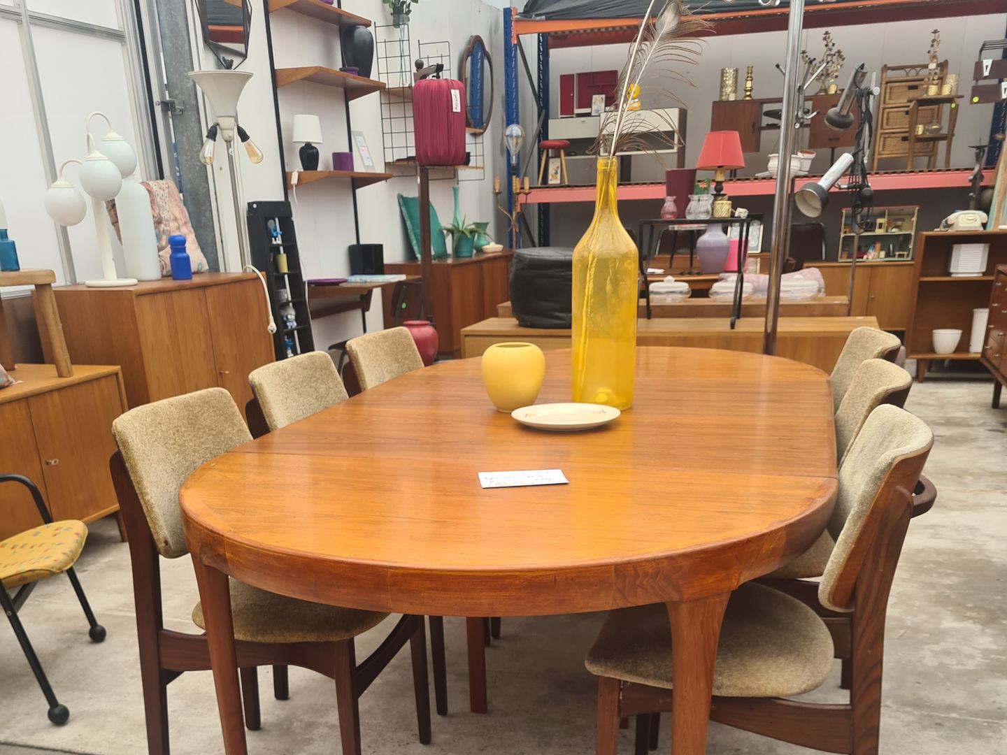 Teakhouten eettafel met stoelen en vintage wandkasten in de loods van DasGaaf