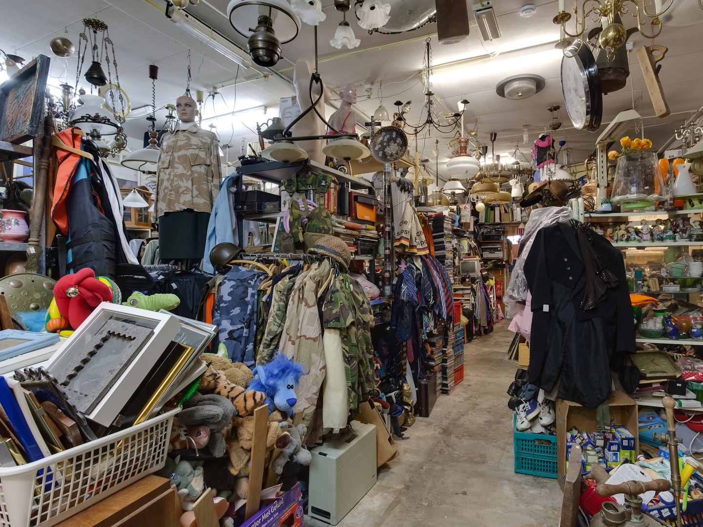Volle winkelruimte van De Flinstones met kleding, lampen, lijsten en huisraad