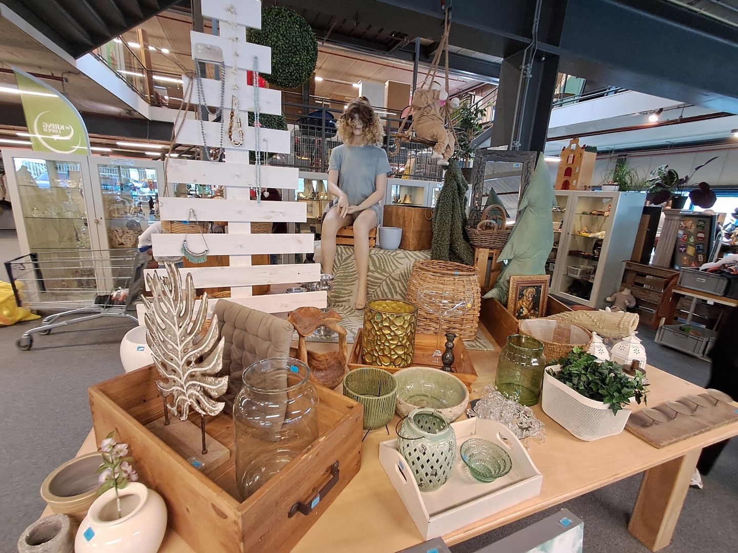 Woonaccessoires, vazen en manden uitgestald op een tafel in De Kringloper Almere