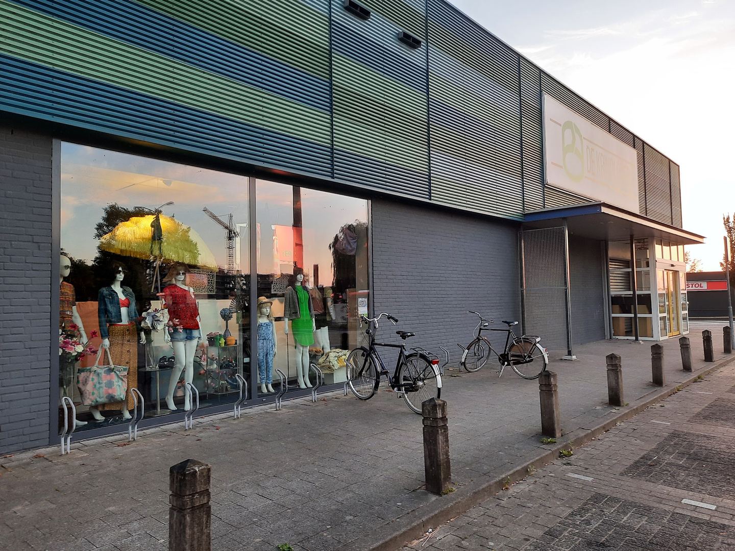 Gevel van De Kringloper met etalage vol paspoppen in kleding