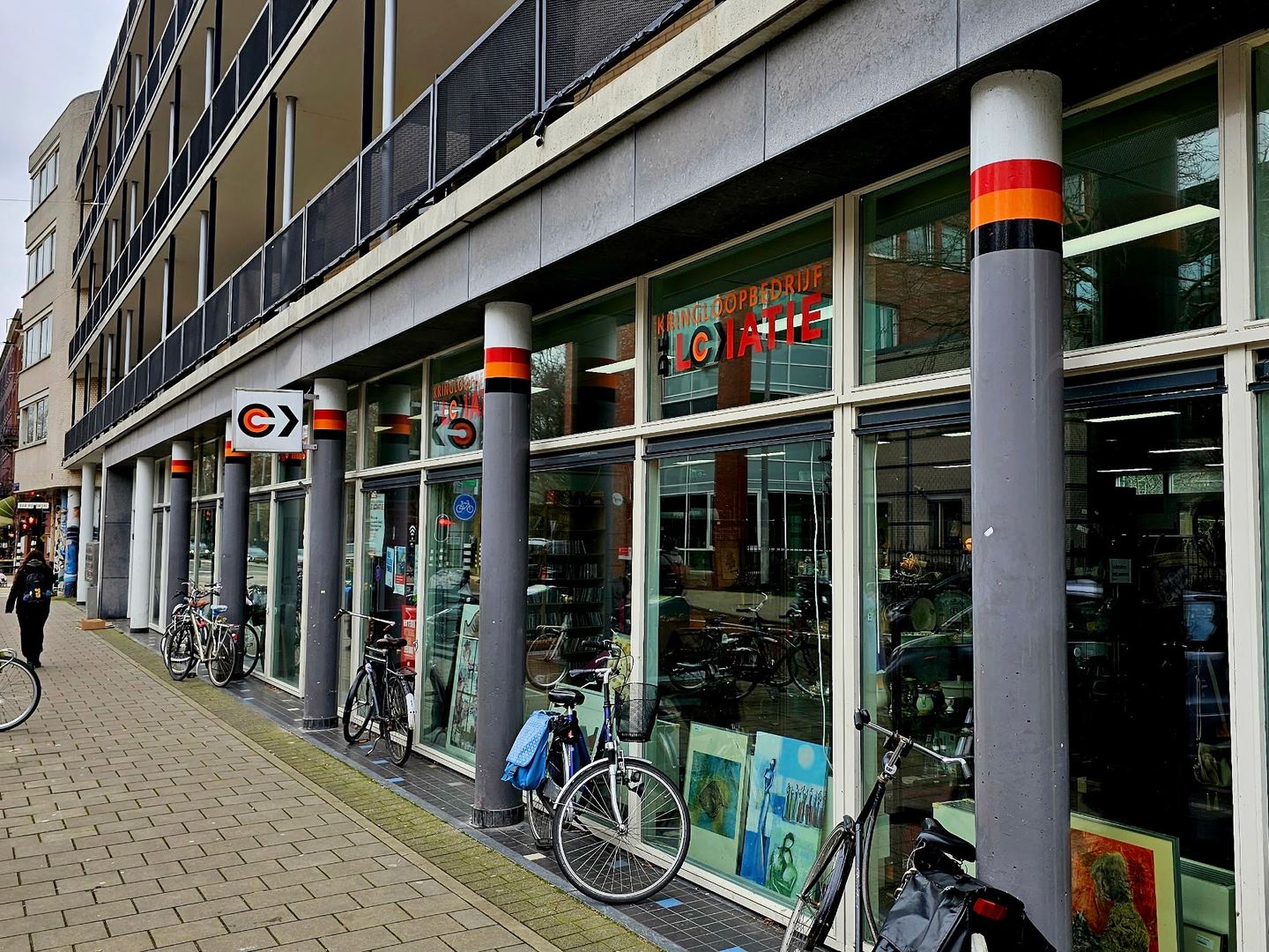 Gevel van kringloopwinkel De Lokatie met grote ramen en het logo boven de ingang