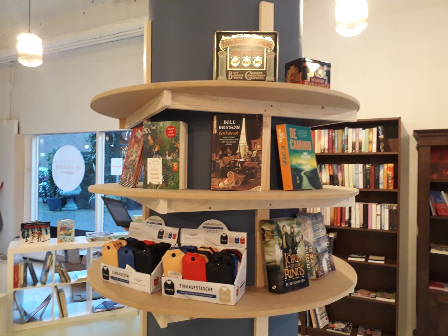Interieur van De Passage met een rond boekenrek vol romans en kasten met tweedehands boeken