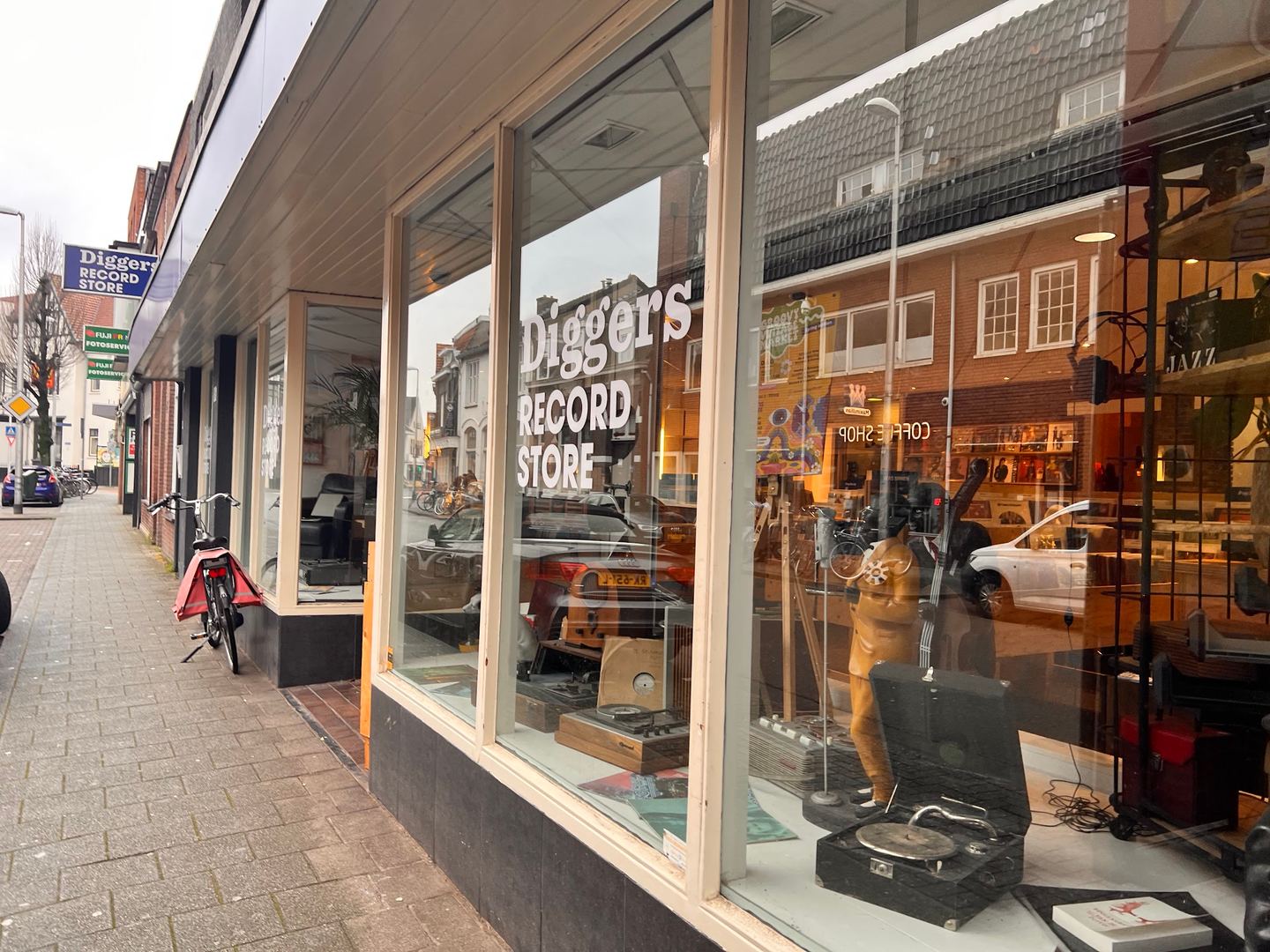 Etalage van Diggers Record Store met een platenspeler en het logo op het raam