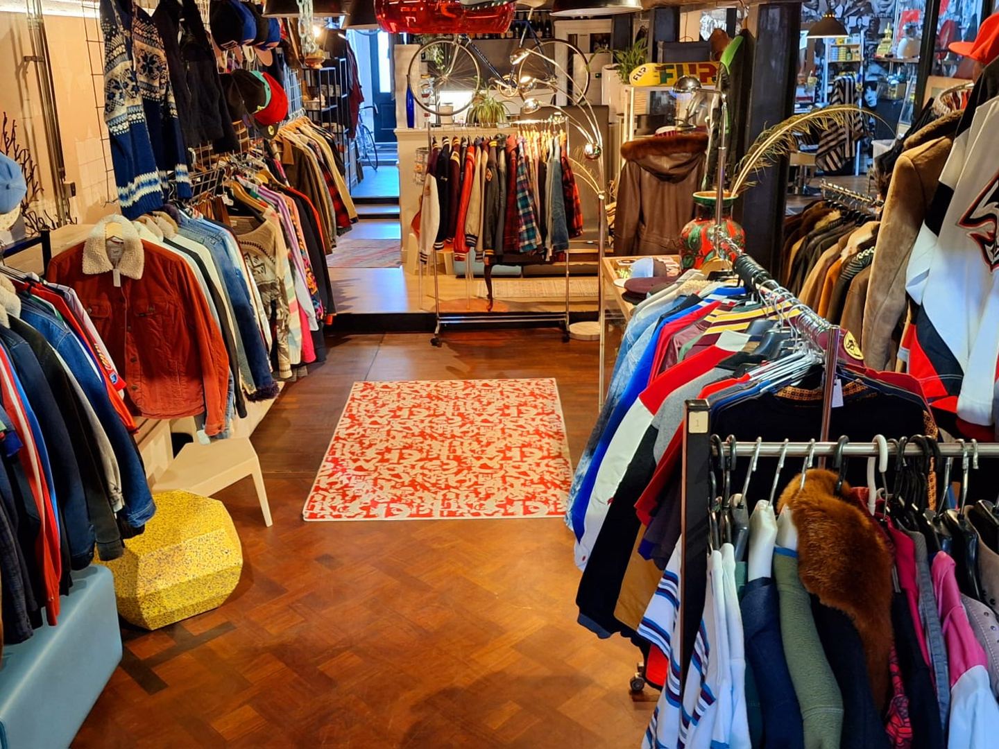 Interieur van EndlessStyles met rekken vol vintage jassen, truien en caps