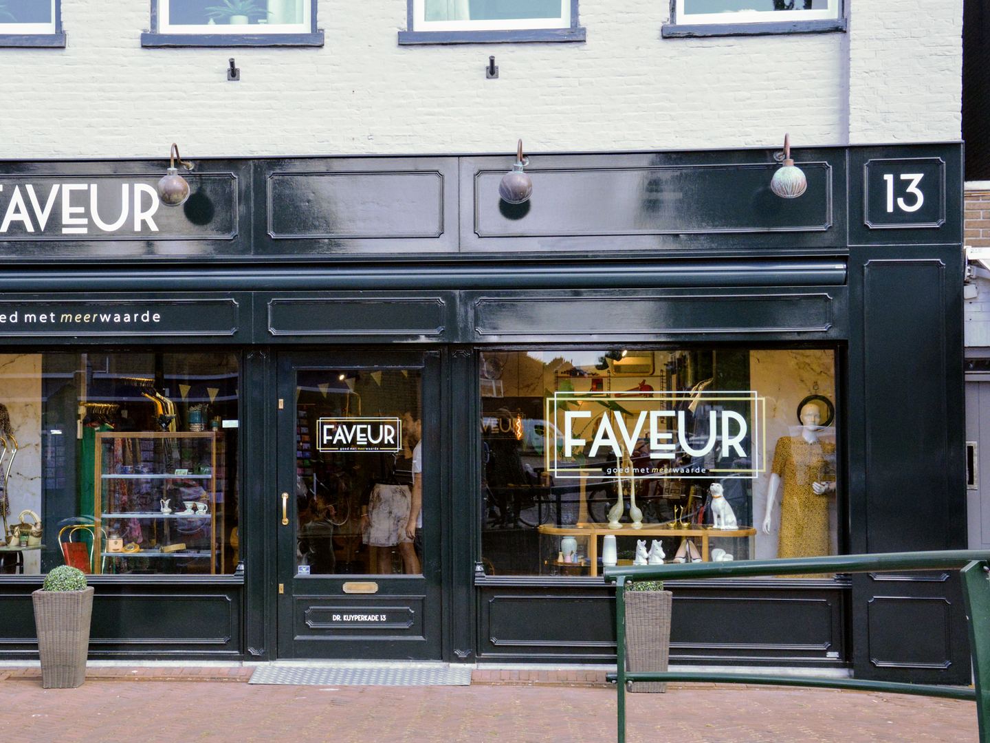 Winkelpui van Faveur met donkergroene gevel en etalages vol kleding en woonaccessoires