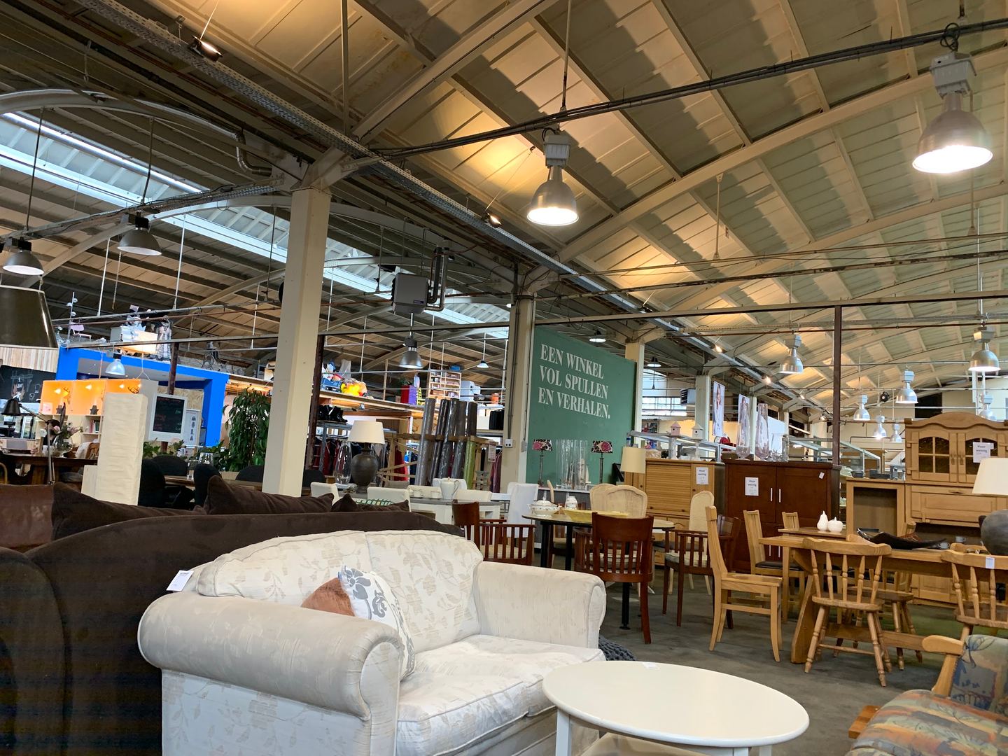 Banken, stoelen en kasten in de grote loods van Foenix op het oude Zwitsalterrein