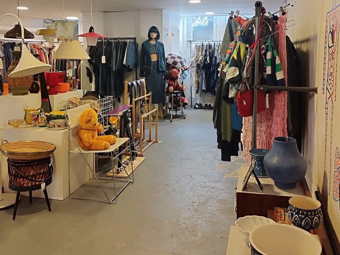 Interieur van Froufrou's met rekken vintage kleding, lampen en meubels