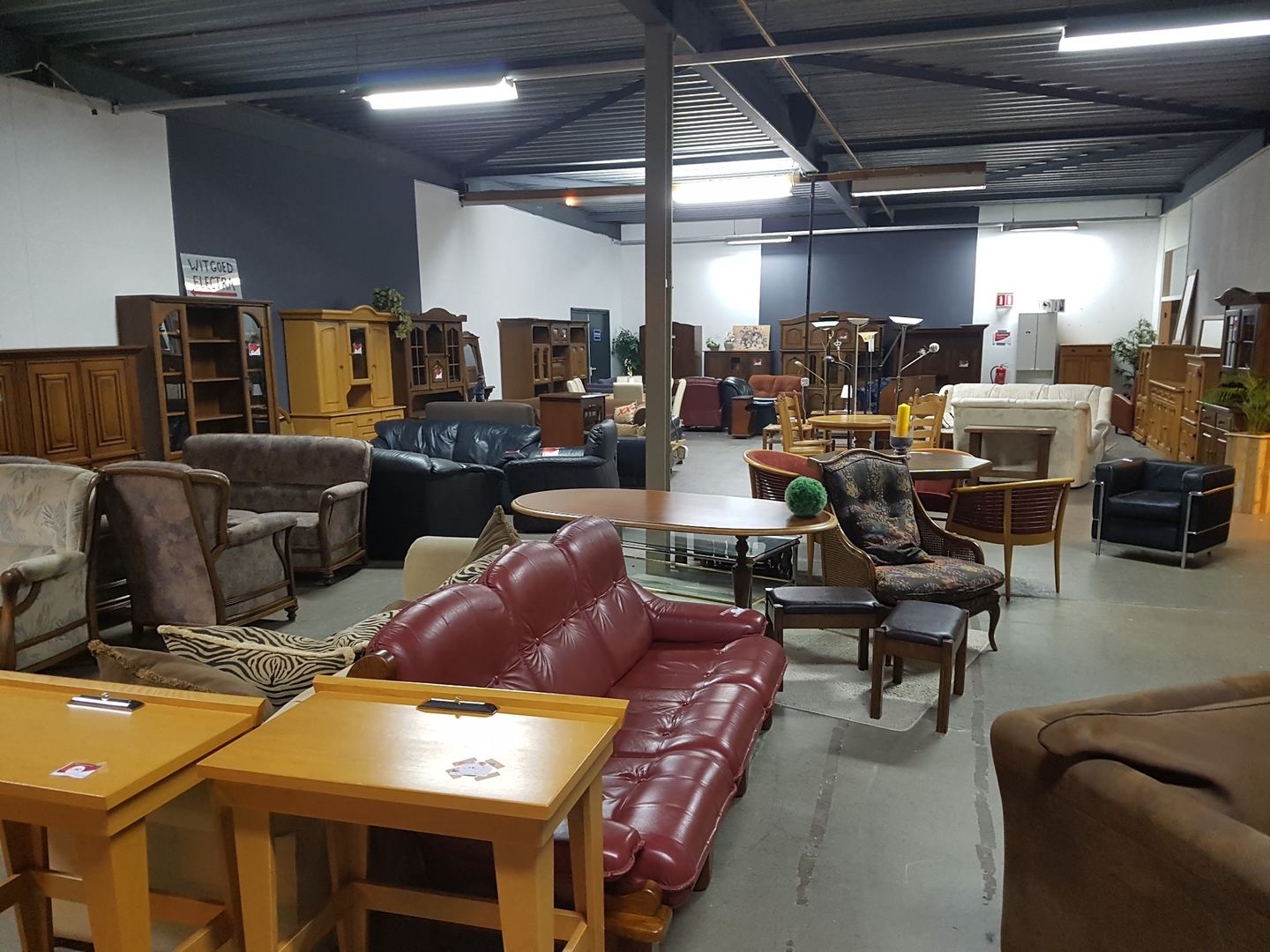 Interieur van GoudGoed Winschoten met tafels, stoelen, kasten en boeken