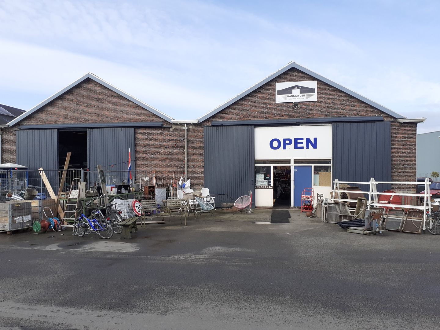Loodsen van Hangar 050 met een open-bord en brocante buiten opgesteld