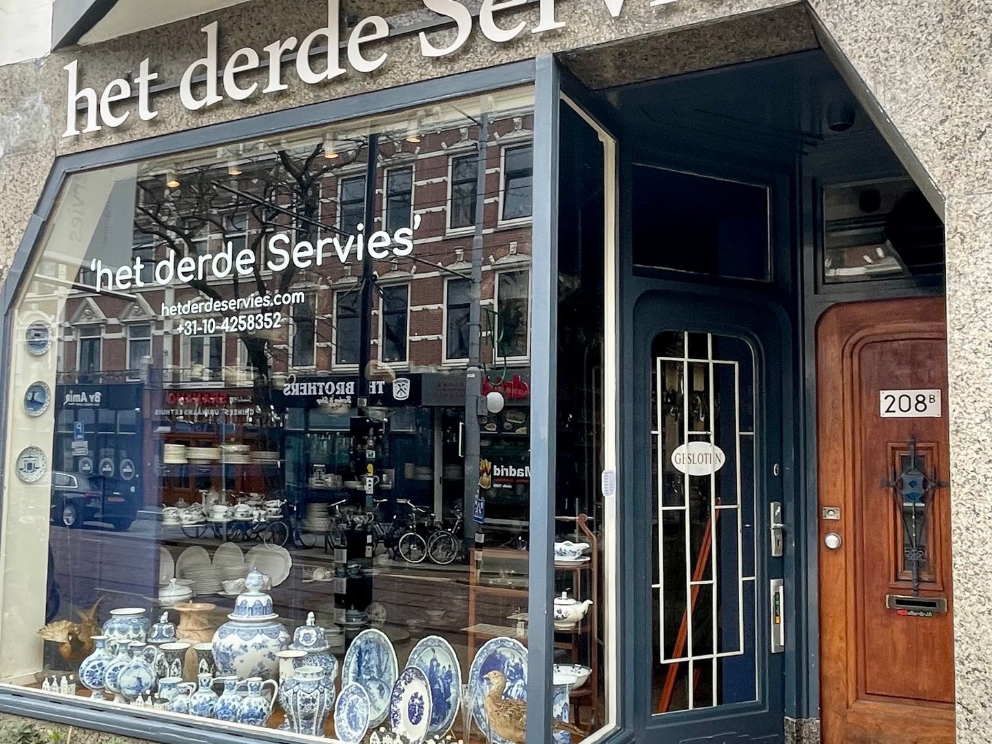 Winkelpui van Het derde Servies met naam op de gevel en een etalage vol blauw-wit porselein