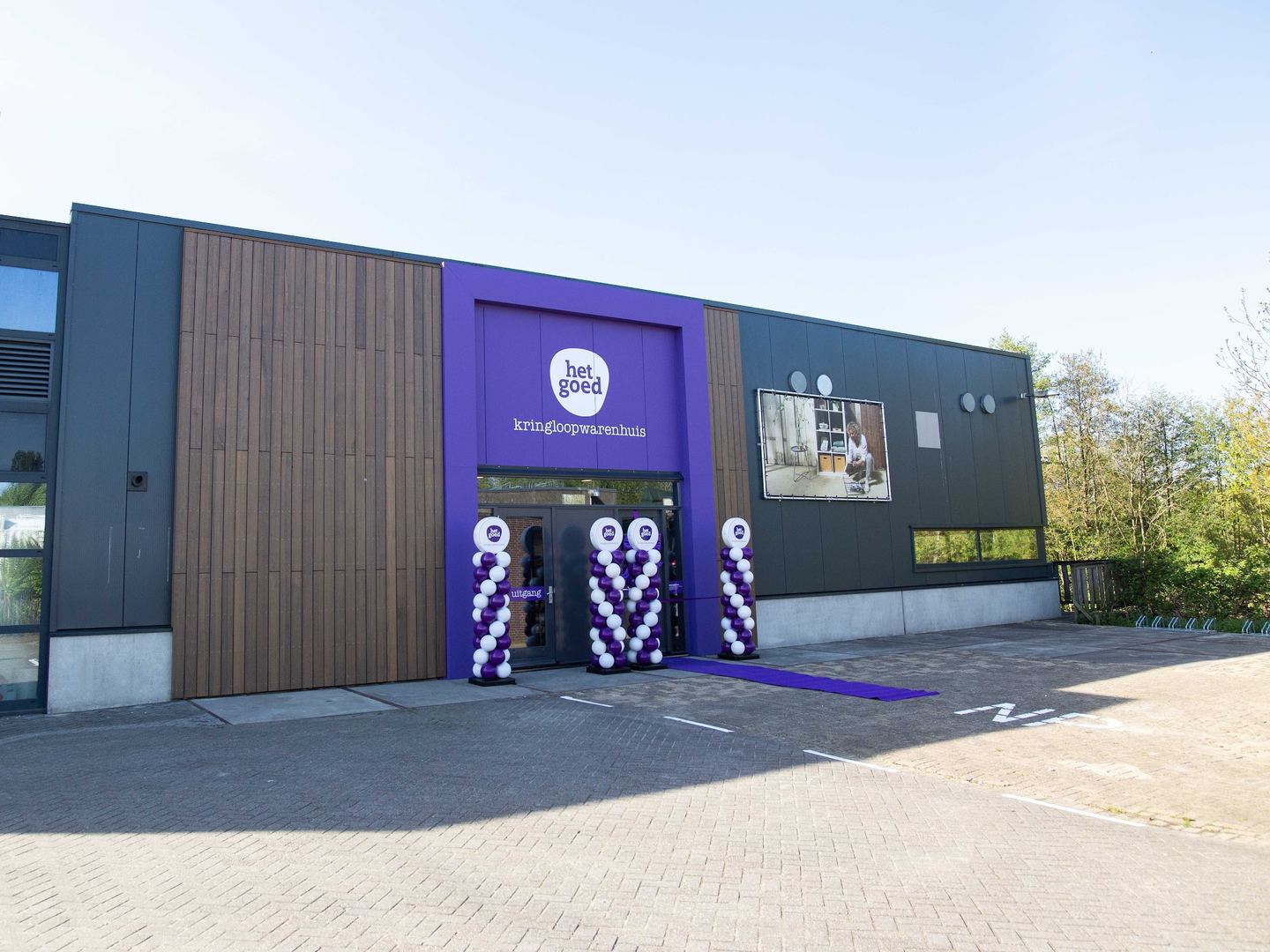 Gevel van Kringloopwarenhuis Het Goed Schiedam met het paarse logo boven de ingang